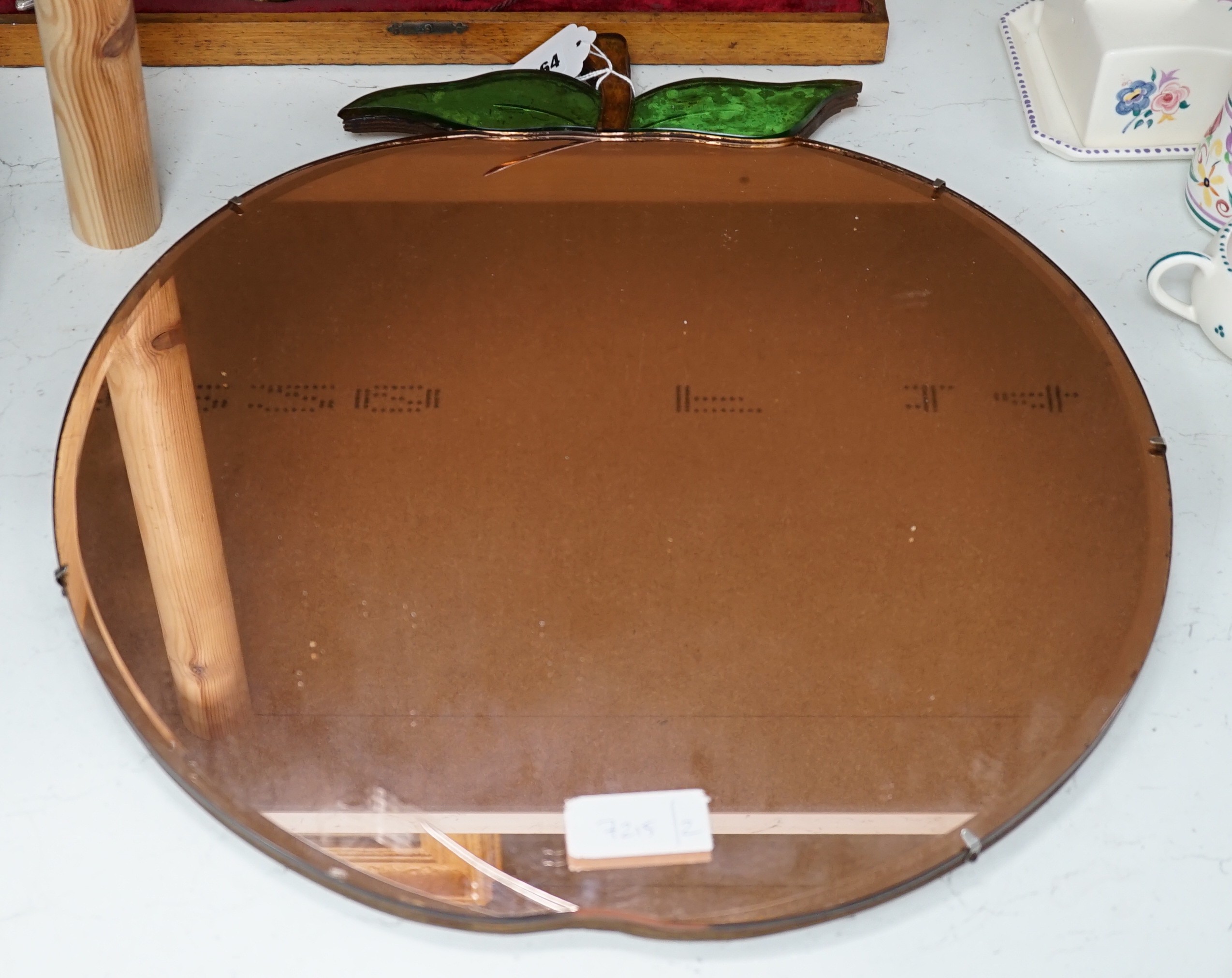 An Art Deco circular wall mirror modelled as a peach. 49cm high